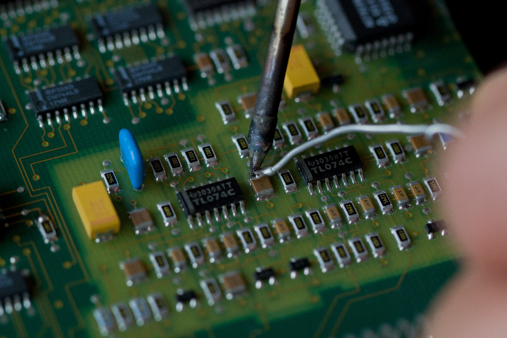 摄图网_506642588_带微芯片的电子板背景上的烙铁和焊料特写电子元件和零件的更换计算机设（非企业商用）.jpg